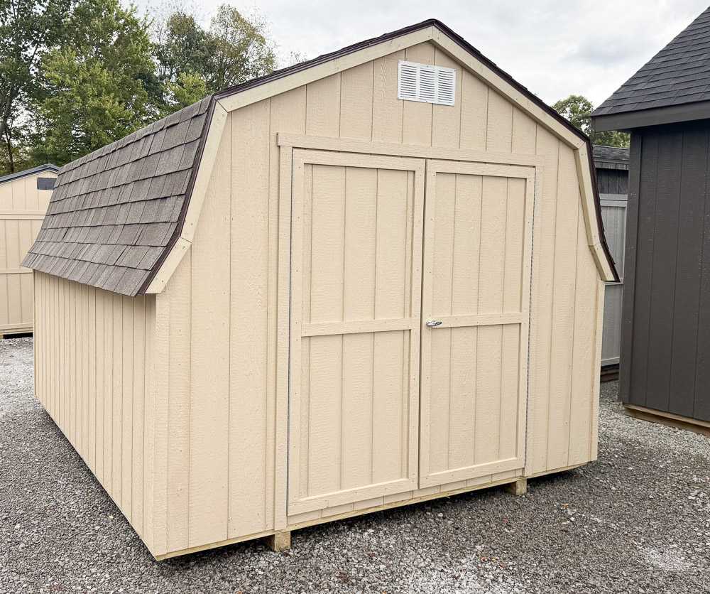 Tan mini barn storage shed from Salem Structures featuring shingle roof, double doors, and classic barn-style roofline.
