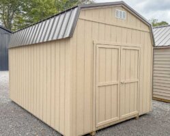 Tan gambrel barn-style storage shed from Salem Structures with metal roof, double front doors, and durable wood siding for backyard storage.